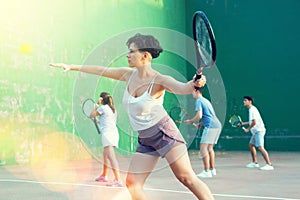 Young Argentinian woman playing frontenis at open-air fronton in summer