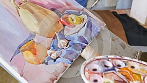 A young artist in an art workshop draws a still-life from nature in watercolor.