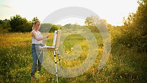 Young artist painting an autumn landscape