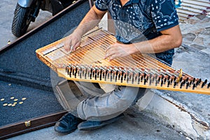 A young artist play music on qanun on the Istanbul city streets to get some money