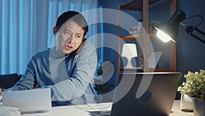 Young Asia businessman use smartphone call meeting agenda assignment paperwork with colleague look at laptop computer in living