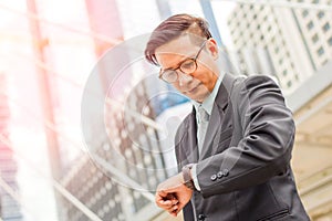 Young Asia handsome businessman looking at his watch