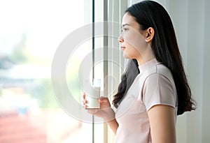 Young Asia woman drinking milk in the bedroom. Feeling happy and refreshment