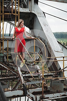 Young asial girl in red dress on iron excavator background