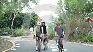 young asian adult cyclists riding bike on rural road