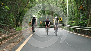 young asian adult cyclists riding bike on rural road