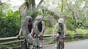 young asian adult cyclists riding bike on rural road