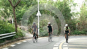 young asian adult cyclists riding bike on rural road