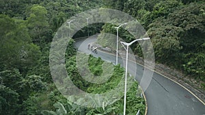 young asian adult cyclists riding bike on rural road