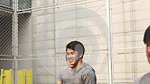 Young asian adult men playing basketball for fun outdoors