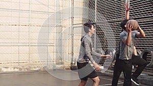 Young asian adult men playing basketball for fun outdoors