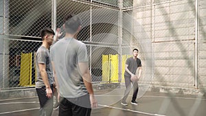 Young asian adult men playing basketball on outdoor court