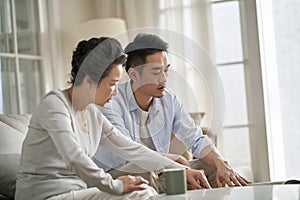 Young asian adult son and elderly mother conversing at home