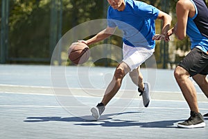 Young asian adults playing basketball