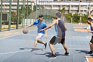 Young asian adults playing basketball