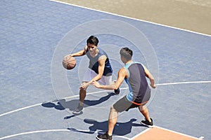 Young asian adults playing basketball