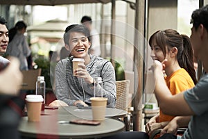 Young asian adults relaxing at outdoor coffee shop