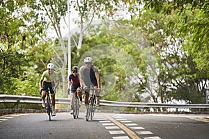 young asian adults riding bike on rural road