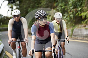 young asian adults riding bike on rural road