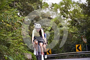 young asian adults riding bike on rural road