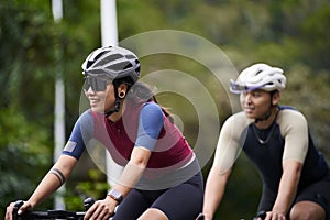 young asian adults riding bike on rural road