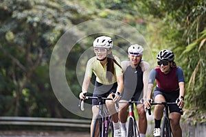 young asian adults riding bike on rural road photo