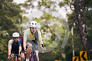 young asian adults riding bike on rural road photo