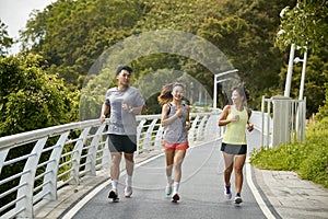 young asian adults running jogging outdoors