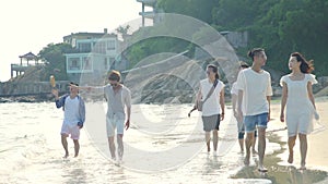 Young asian adults walking on beach