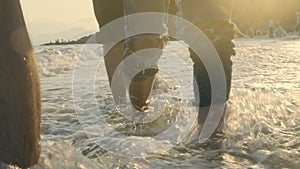 Young asian adults walking on beach in sea water