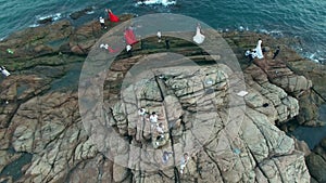 Young asian adults walking on rocks by the sea