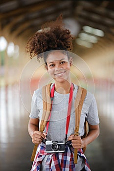 Young Asian African woman traveler with backpack in the railway train station, traveler girl walking stand sit waiting