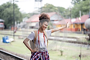 Young Asian African woman traveler with backpack in the railway train, traveler girl walking stand sit waiting take a