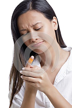 Young Asian American woman with injjured finger on white background