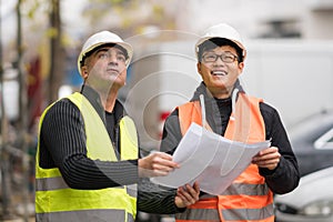 Young Asian apprentice at work with senior engineer
