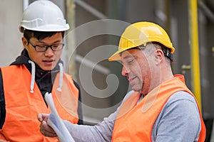 Young Asian apprentice at work with senior engineer