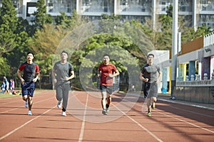 Young asian athletes running on track