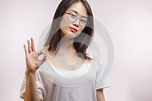 Young Asian attractive woman wearing her new optical glasses , showing OK sign