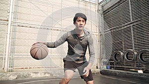 Young asian basketball player training on outdoor court