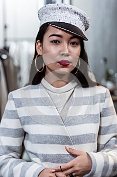 Young asian beaming woman with red lipstick looking contented