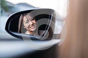 Young asian beautiful woman driving a car with fastened seatbelt