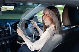 Young asian beautiful woman driving a car with fastened seatbelt