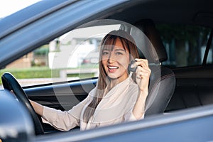 Young asian beautiful woman driving a car with fastened seatbelt