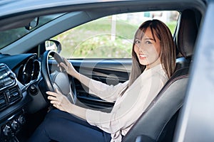 Young asian beautiful woman driving a car with fastened seatbelt