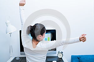 Young Asian beautiful woman sitting in front of computer and stretch oneself after long working. stree-free and relax