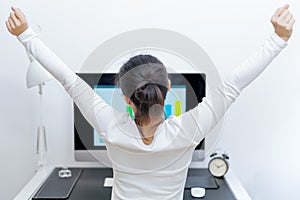 Young Asian beautiful woman sitting in front of computer and stretch oneself after long working. stress-free and relax