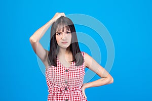 Young Asian beautiful woman wearing red dress on blue background suffering from headache desperate and stressed because pain and