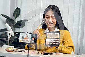 Young Asian beauty blogger is showcasing cosmetic products as well as tutorials on how to apply and record makeup tutorials on