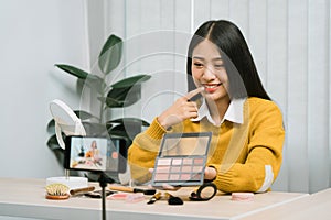 Young Asian beauty blogger is showcasing cosmetic products as well as tutorials on how to apply and record makeup tutorials on