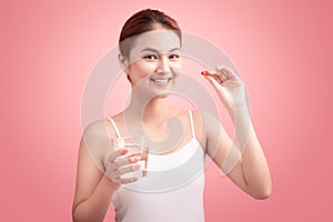 Young asian beauty young woman eating pills and drinking water o